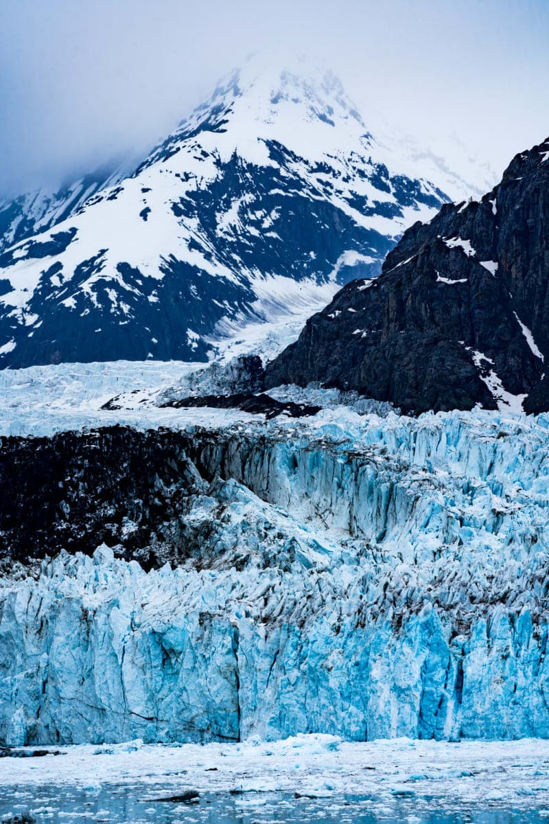 A massive glacier flowing between mountain peaks in Alaska